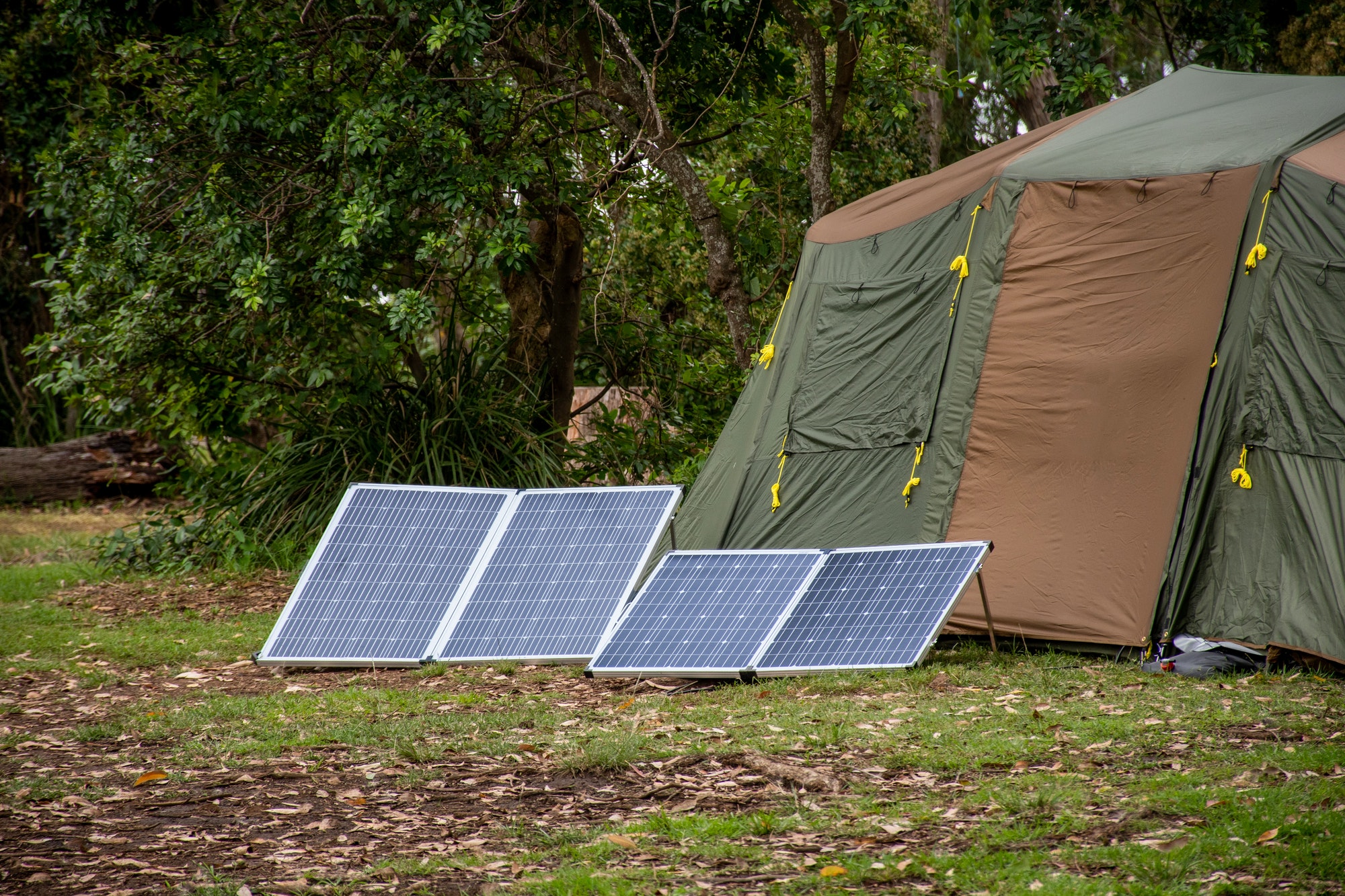 Camping with solar panels. Portable foldable solar panels near the tent.