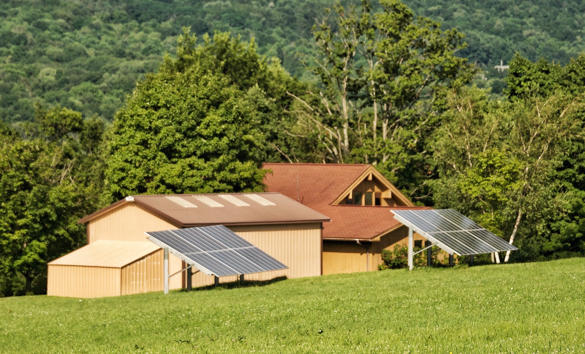 Solar energy panels on the rooftop of a country home near a forest